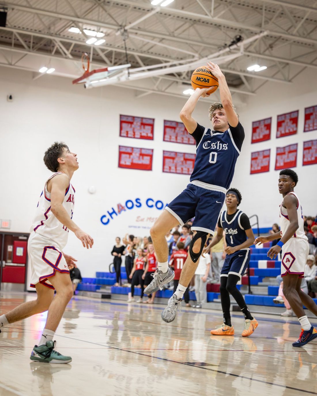 Jack Gaston rising for a jump shot in the navy road jersey